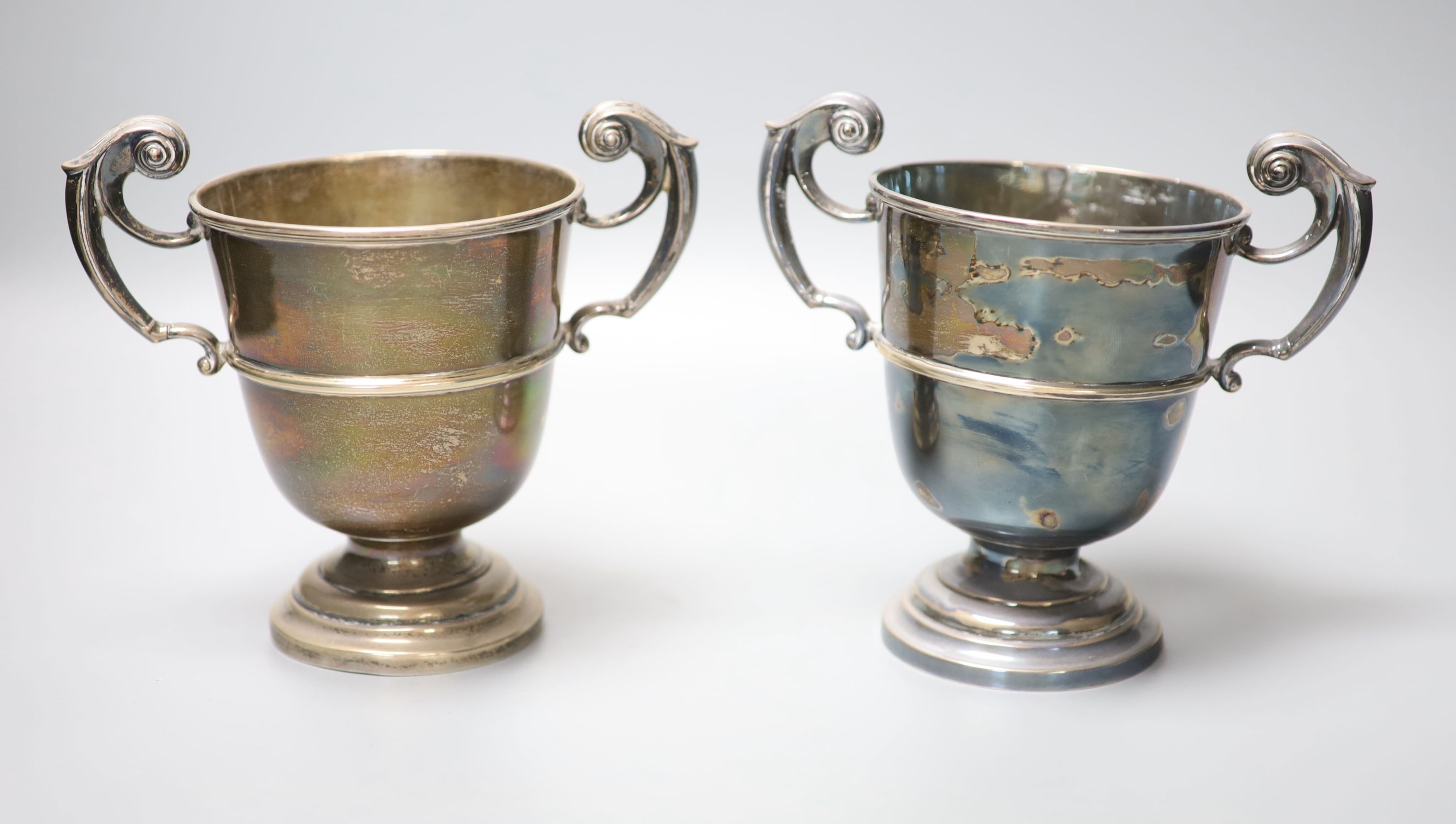 A pair of late Victorian silver two handled pedestal trophy cups, James Deakin & Sons, Sheffield 1900, 16cm, 28oz.